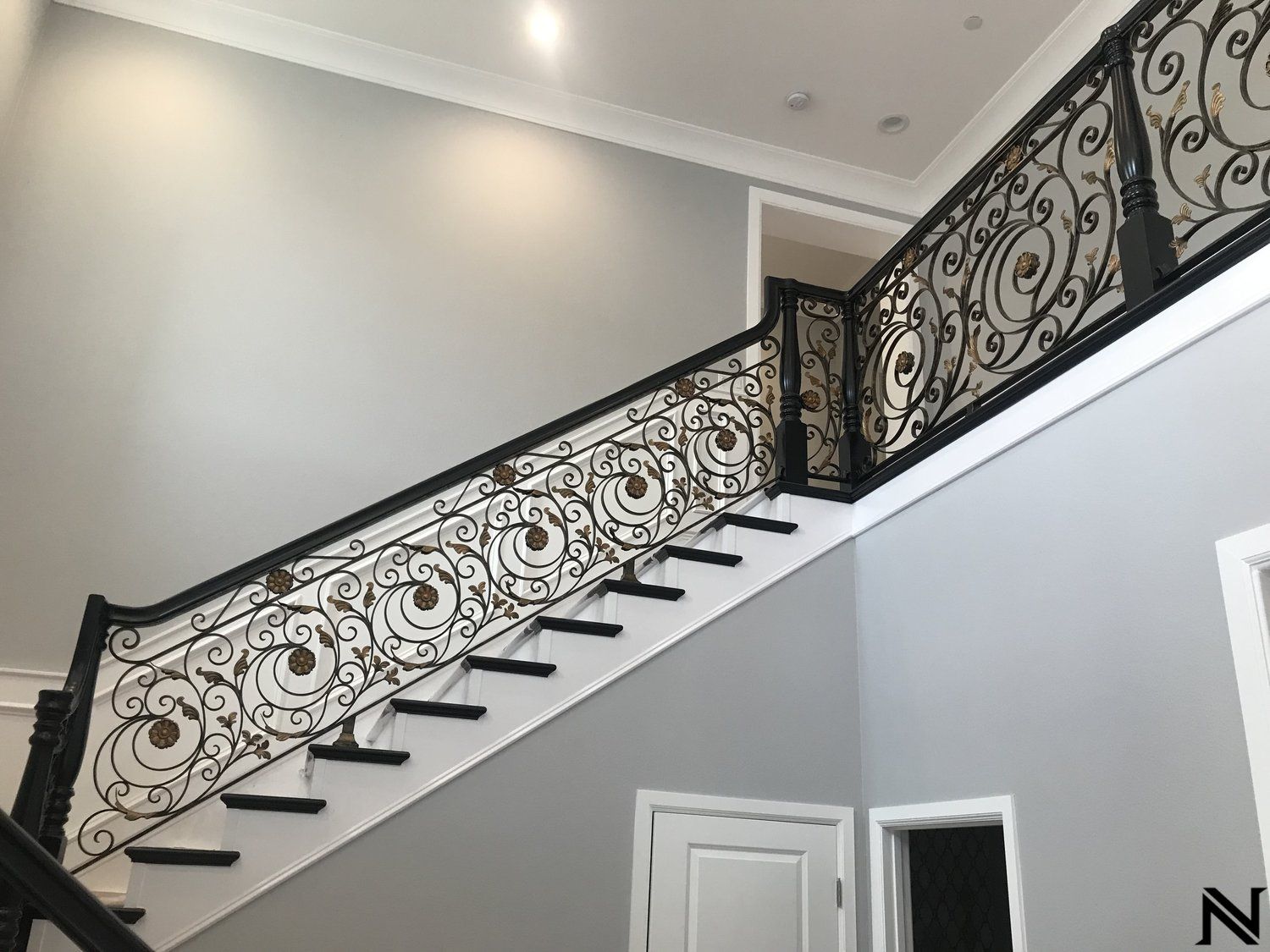 A staircase with a wrought iron railing in a house.