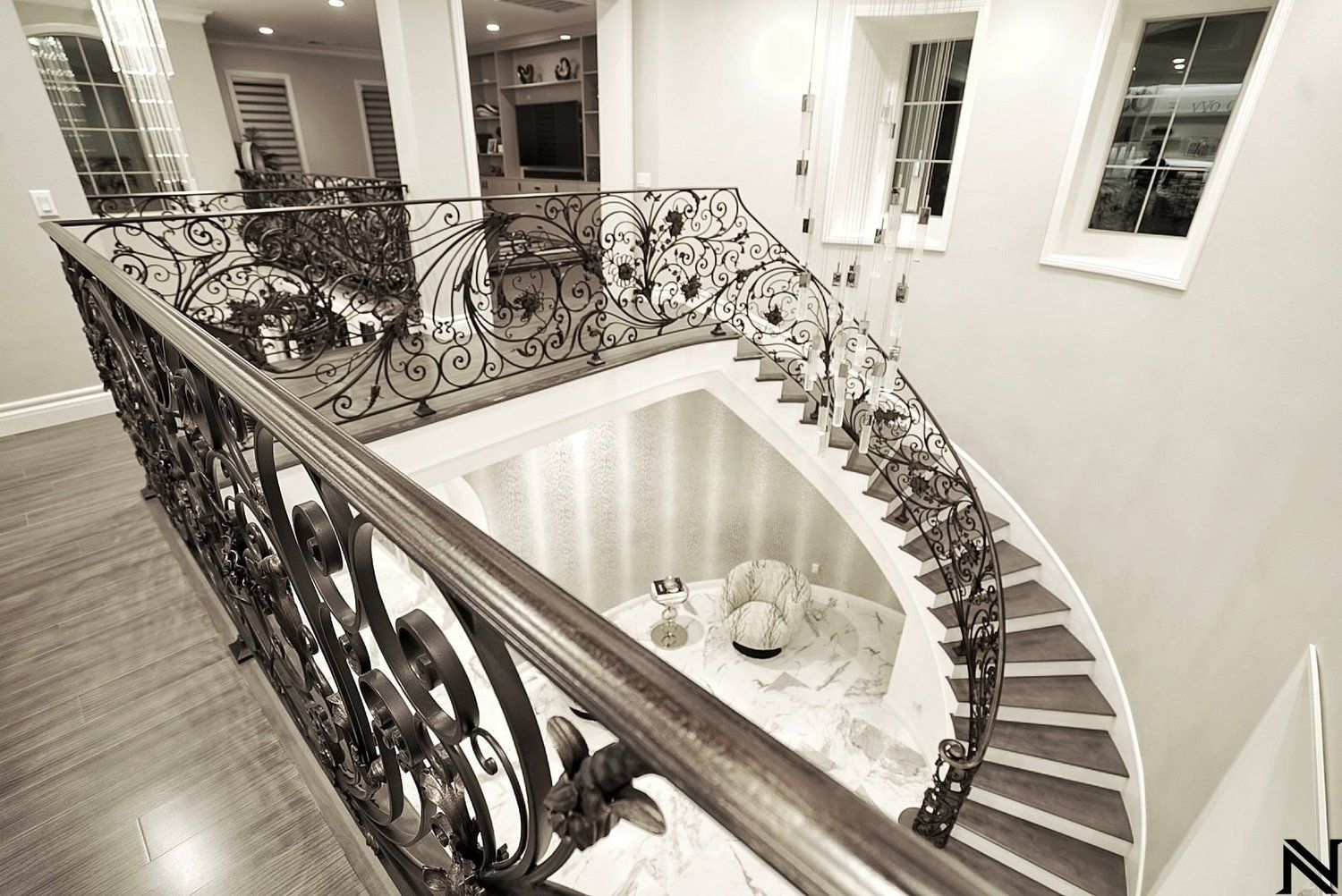 A black and white photo of a staircase with a wrought iron railing