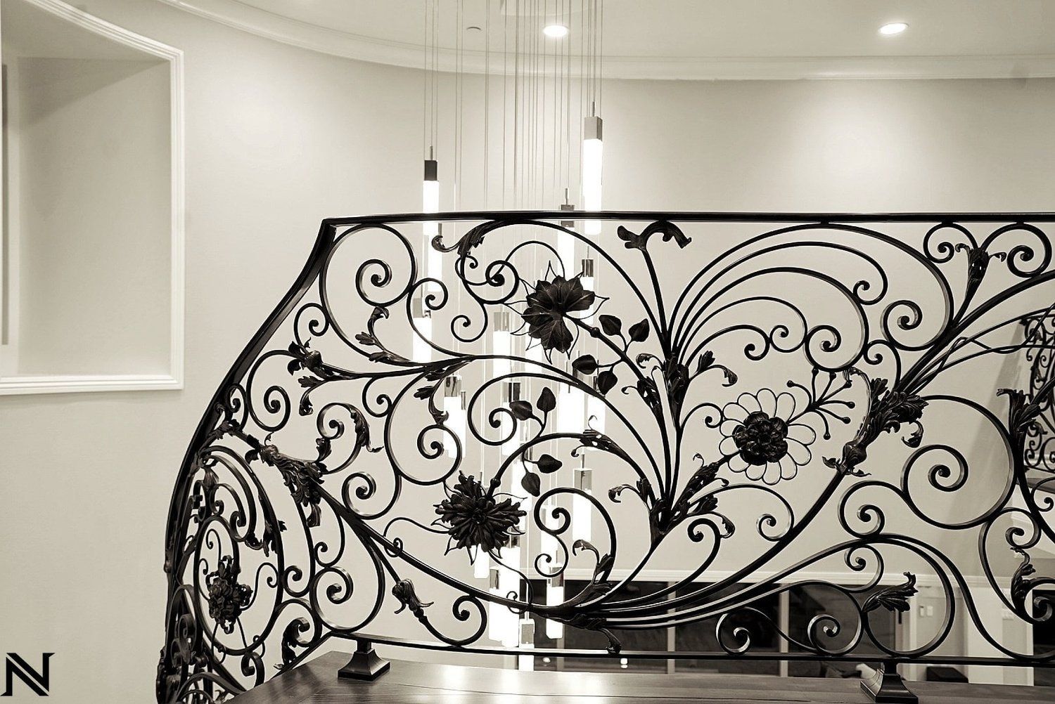 A black and white photo of a wrought iron railing on a staircase.