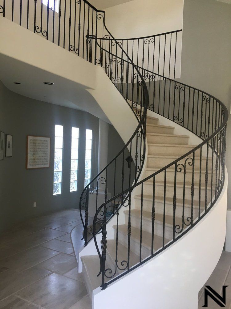 A spiral staircase with a wrought iron railing in a house