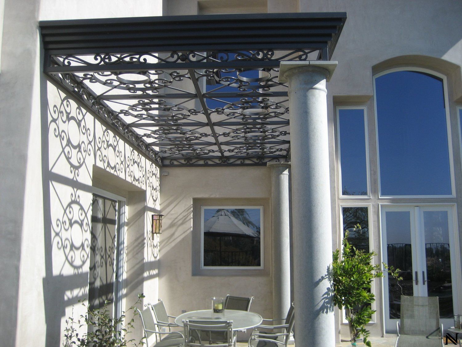 A patio with a table and chairs under a pergola