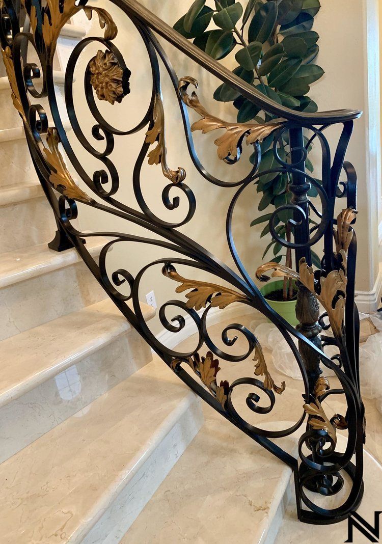 A close up of a wrought iron railing on a set of stairs.