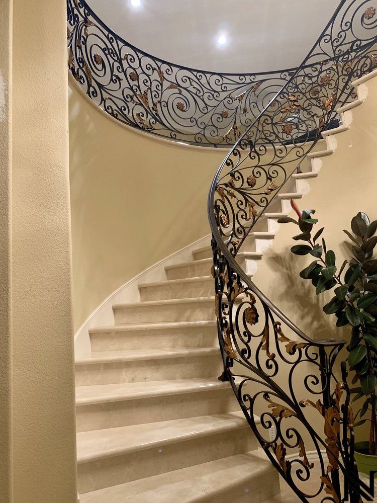 A spiral staircase with a wrought iron railing in a house.
