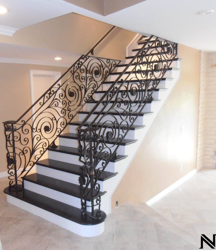 A black and white staircase with a wrought iron railing