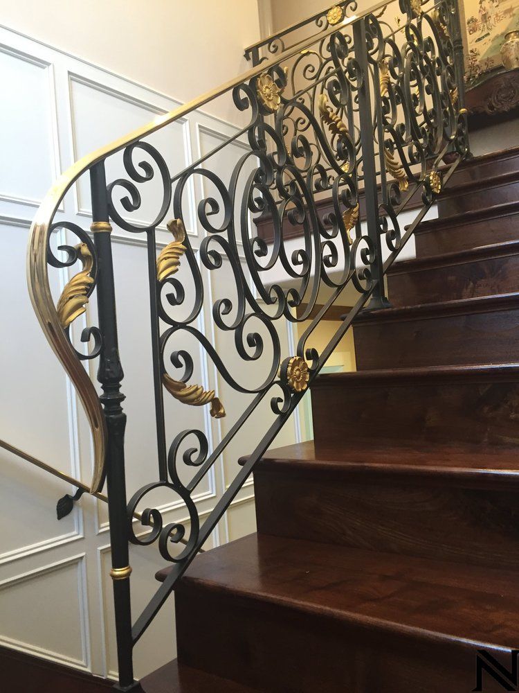 A staircase with a wrought iron railing and wooden steps