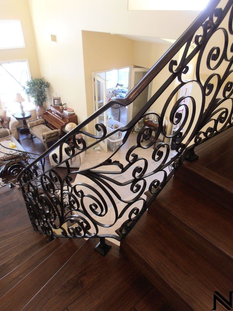 A staircase with a wrought iron railing leading up to a living room