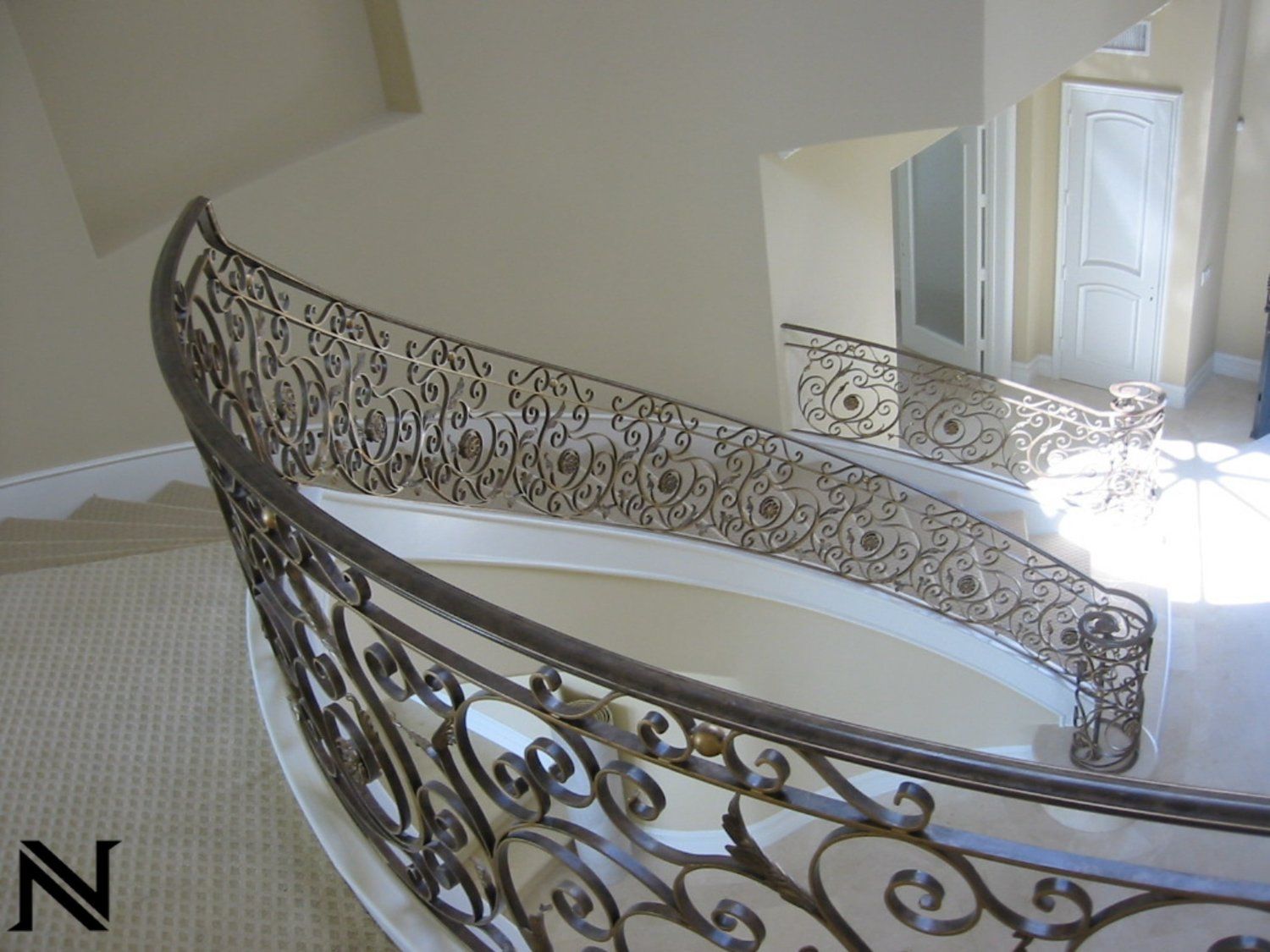 A wrought iron railing on a curved staircase in a house