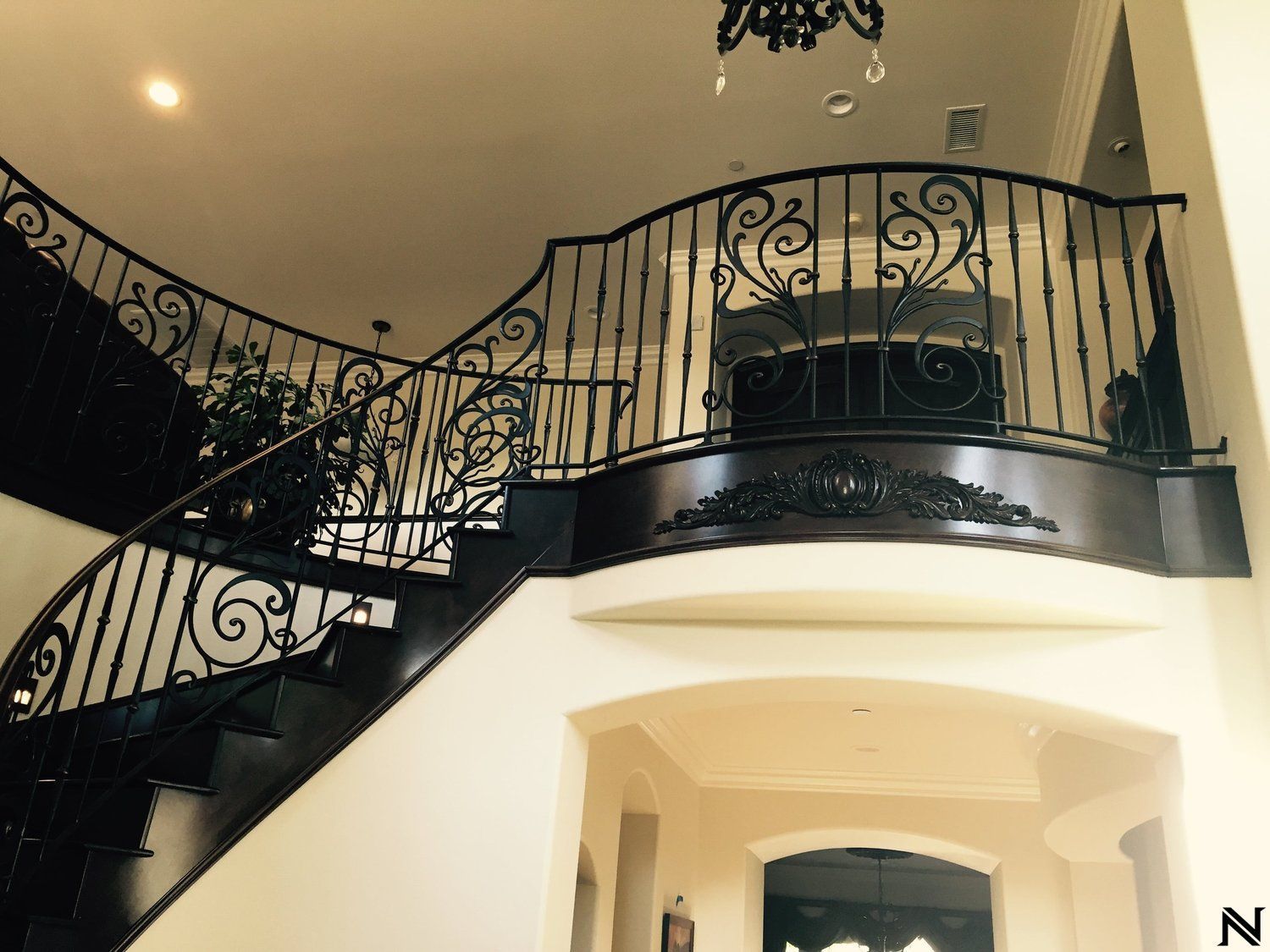 A staircase in a house with a wrought iron railing