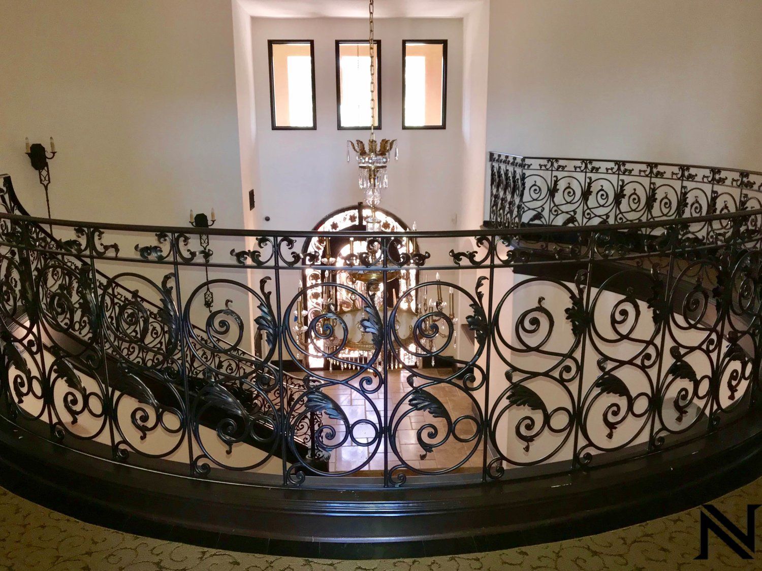 A wrought iron railing with the letter n in the corner