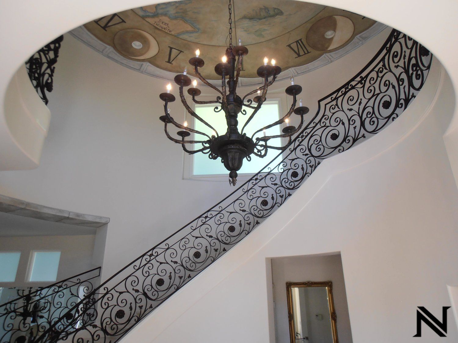 A chandelier hangs from the ceiling above a staircase