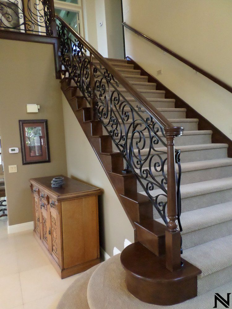 A staircase with a wrought iron railing and the letter n on the bottom
