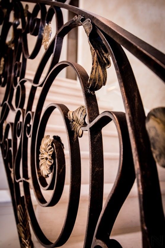 A close up of a wrought iron railing on a set of stairs