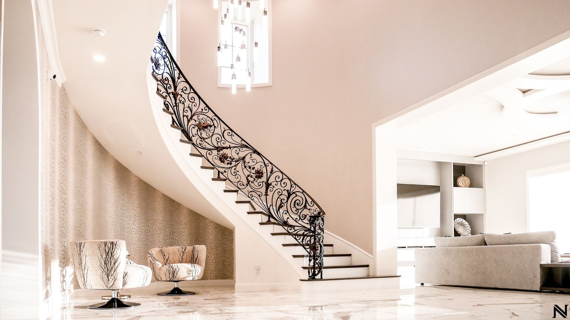 A curved staircase in a living room with a wrought iron railing.