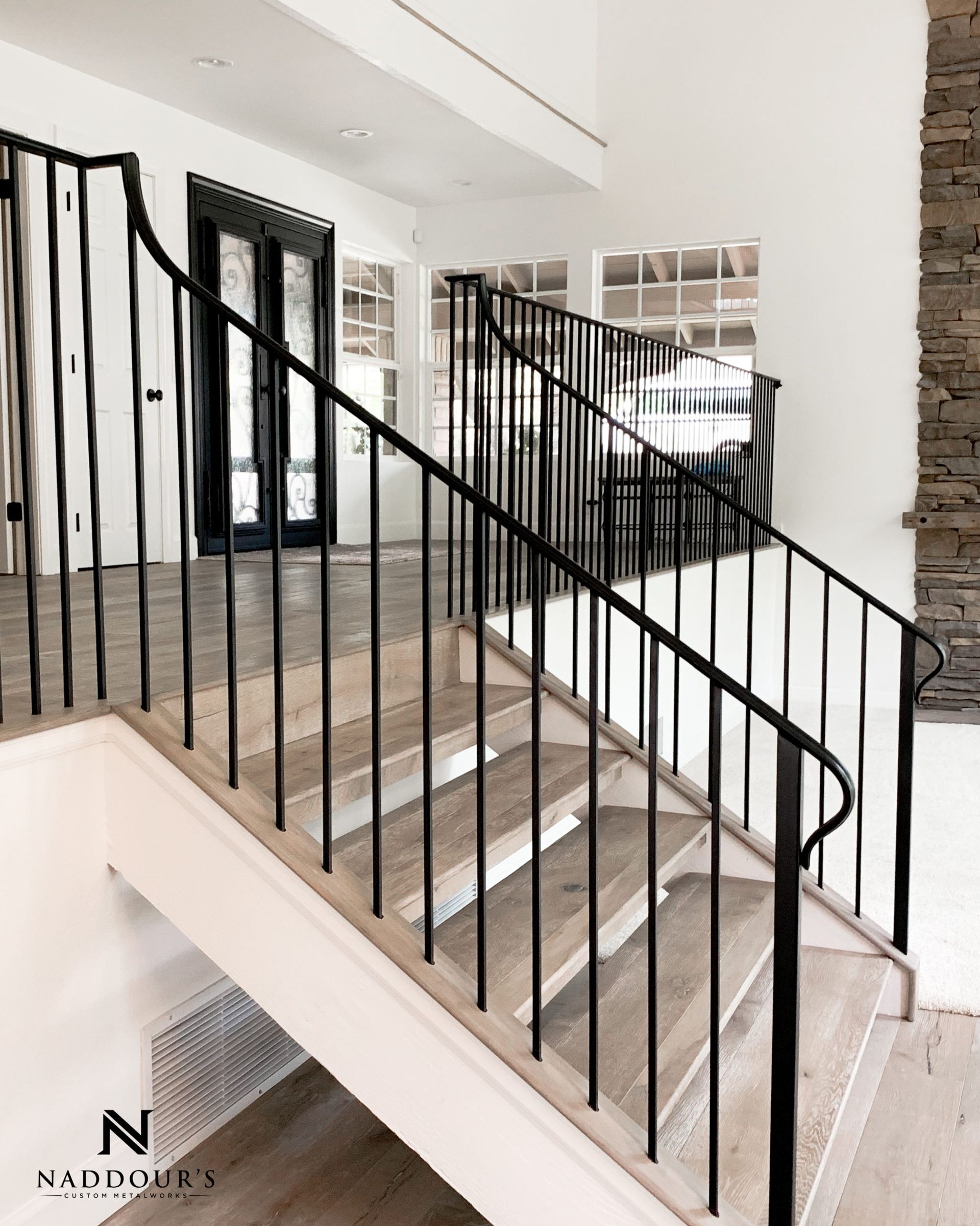 A staircase with a black railing and wooden steps