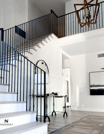 A white staircase with a black railing leading up to the second floor