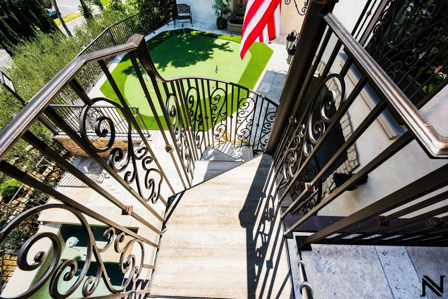 An aerial view of a spiral staircase with a wrought iron railing