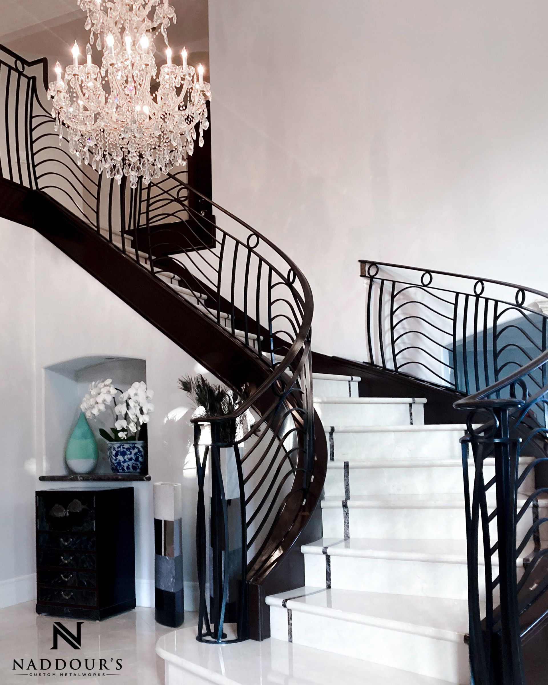 A staircase with a chandelier hanging from the ceiling
