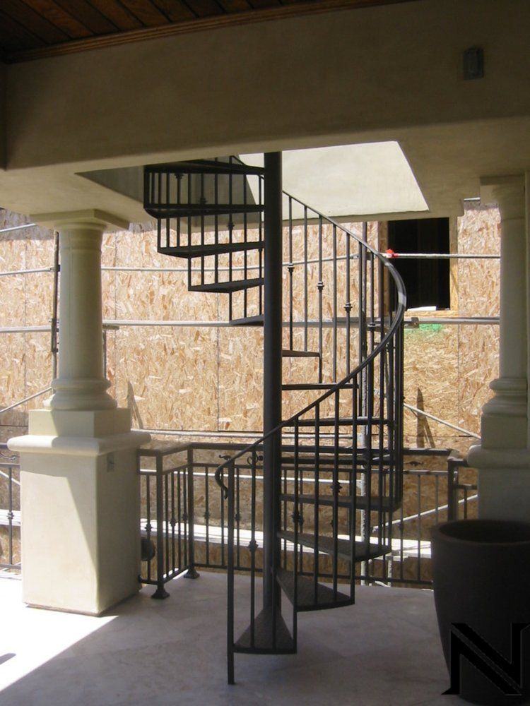 A spiral staircase leading up to the second floor of a building