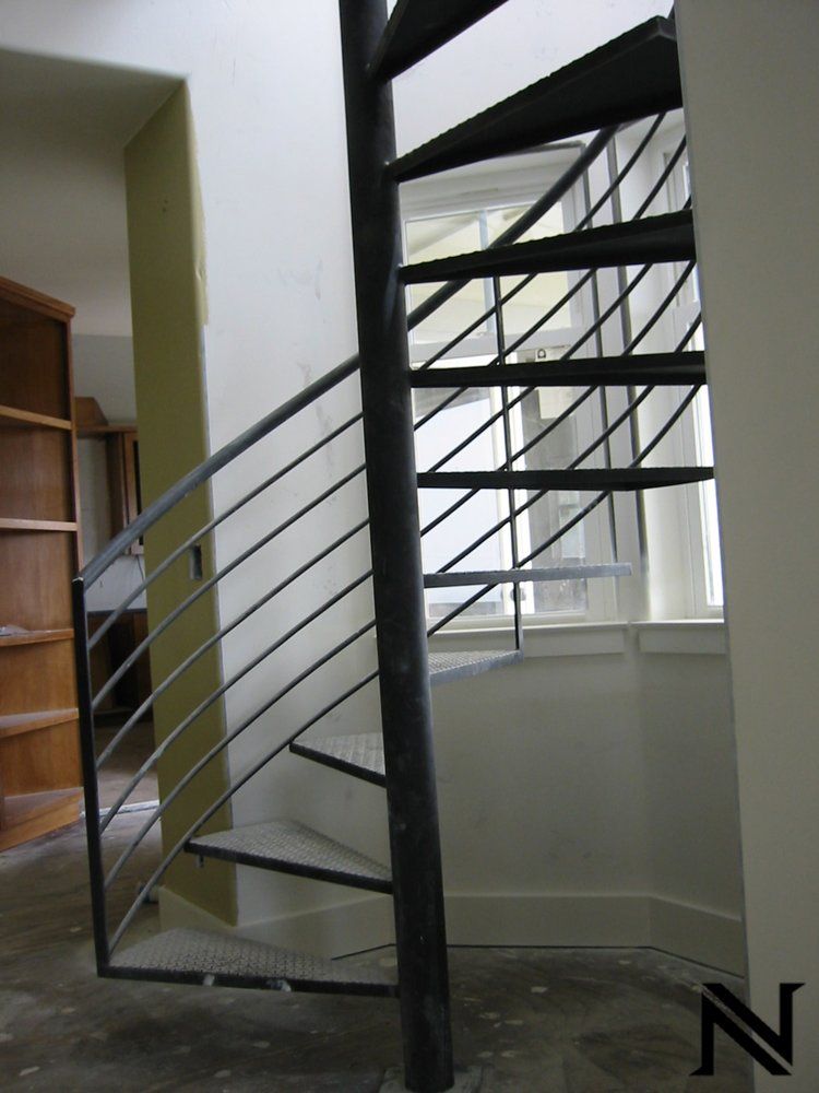 A spiral staircase with the letter n on the wall