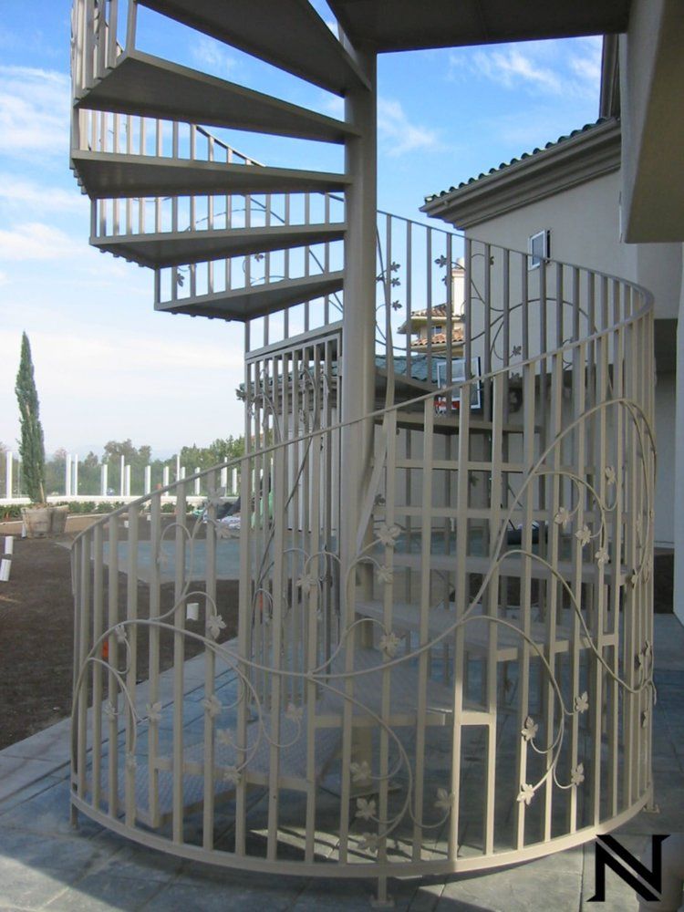 A spiral staircase is surrounded by a fence with the letter n on it
