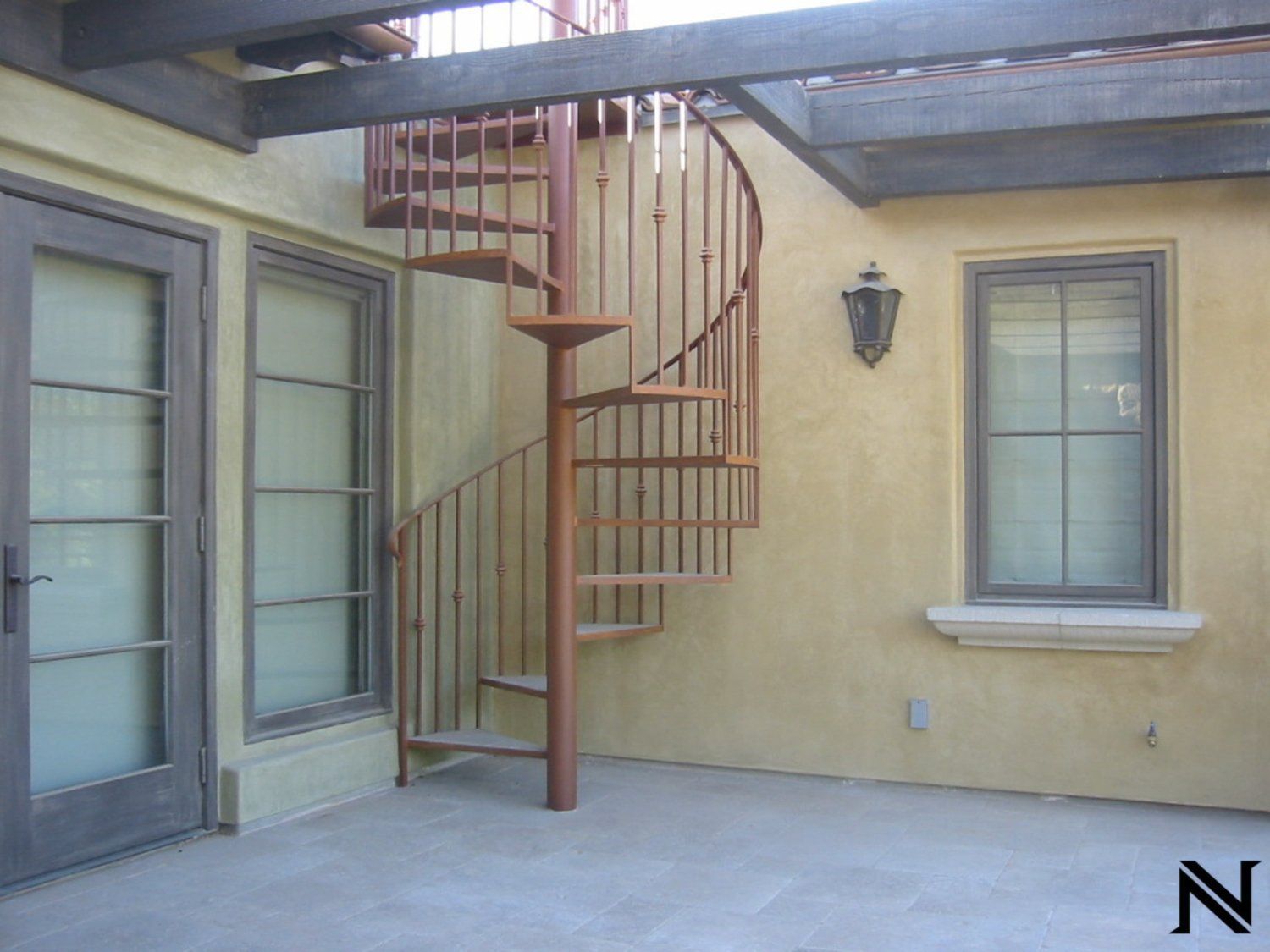 A spiral staircase on the side of a building with the letter n below it