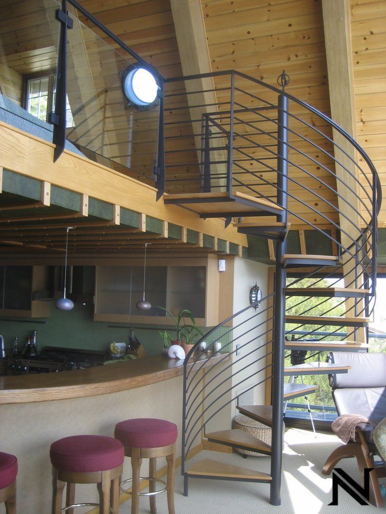 A kitchen with a spiral staircase leading to the second floor