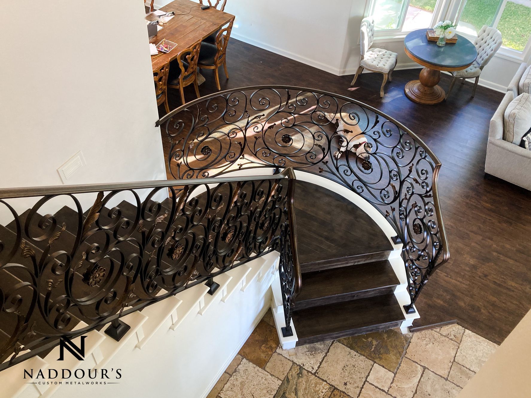 A spiral staircase with a wrought iron railing in a living room.