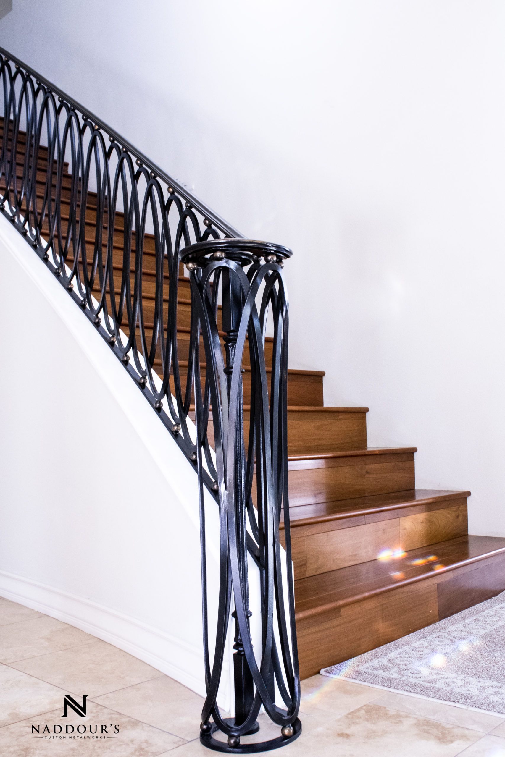A staircase with a wrought iron railing and wooden steps
