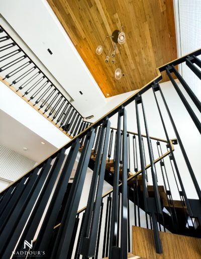 A staircase with a black railing and wooden steps