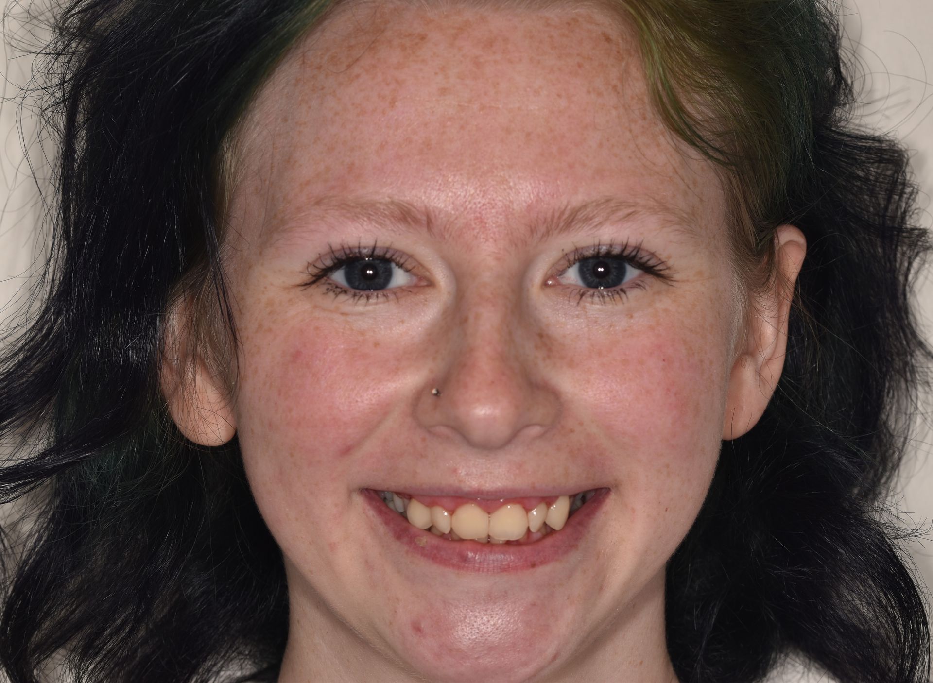 A close up of a woman 's face with a smile on her face.
