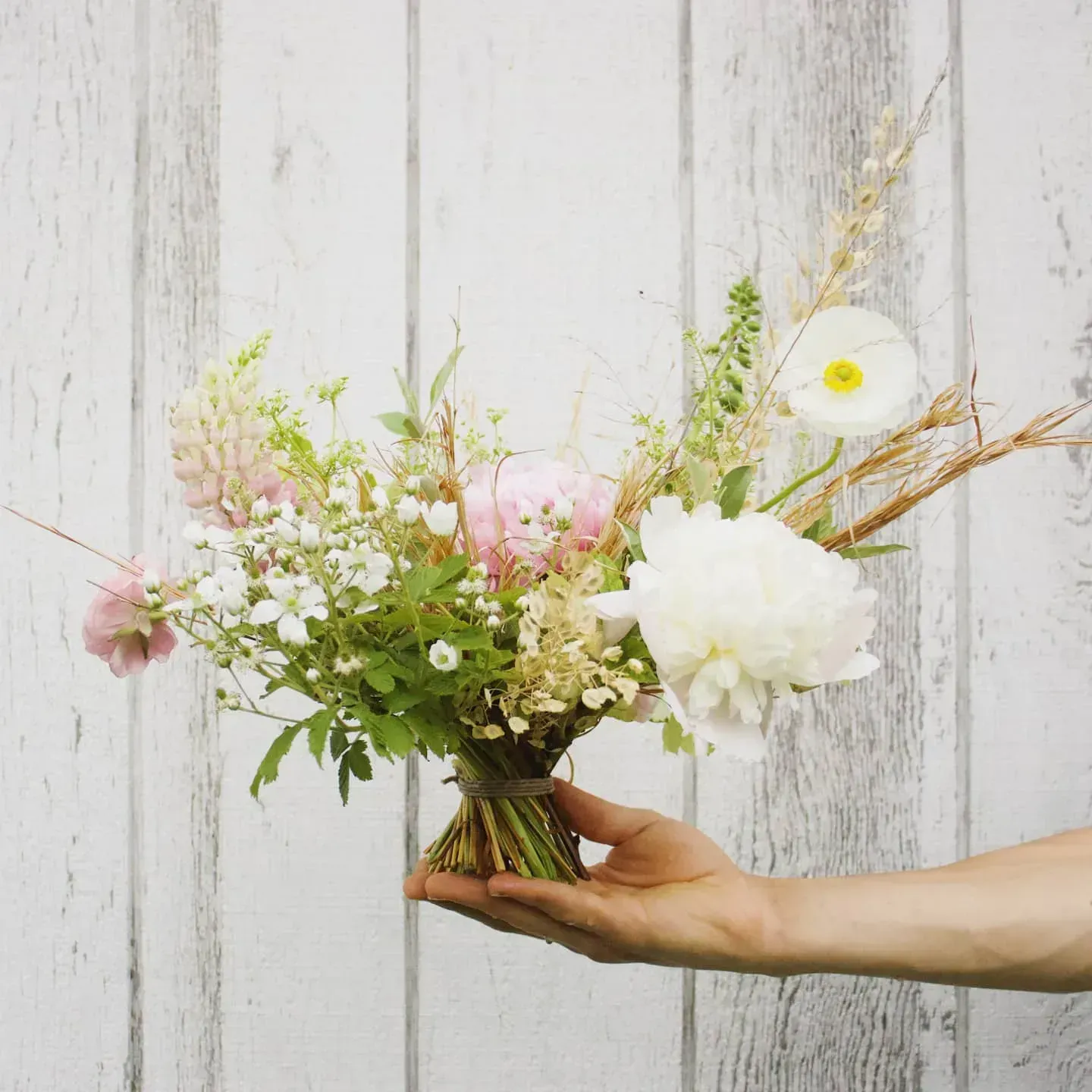 A person is holding a bouquet of flowers in their hand