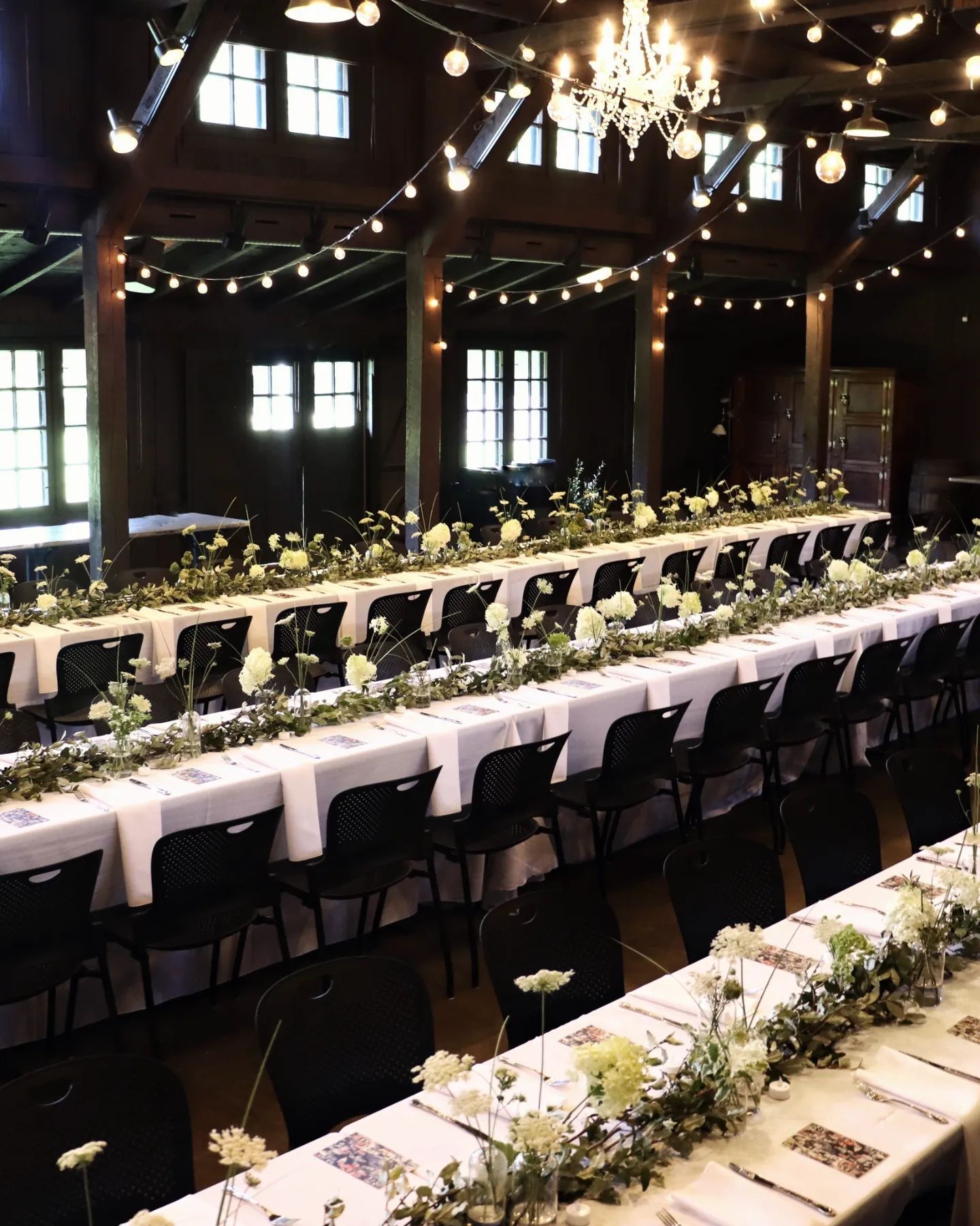 A large room with tables and chairs set up for a wedding reception.
