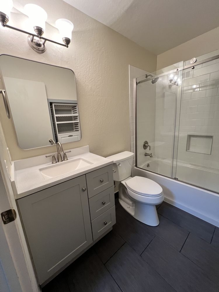 Modern bathroom with vanity, mirror, toilet, and glass shower enclosure