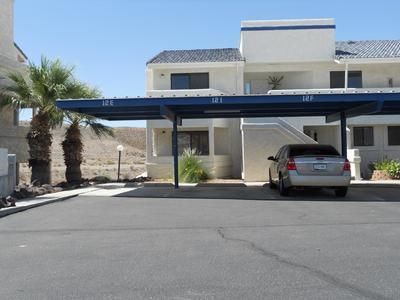 A car is parked under a canopy in front of a building