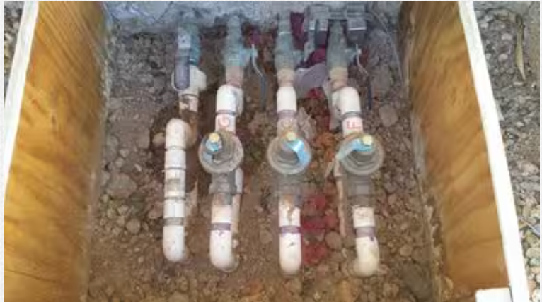 Three water meters are sitting in a wooden box.