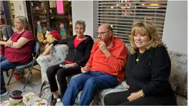 A group of people are sitting on a couch in a living room.