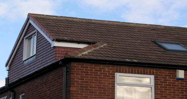 A brick house with a brown roof and a window