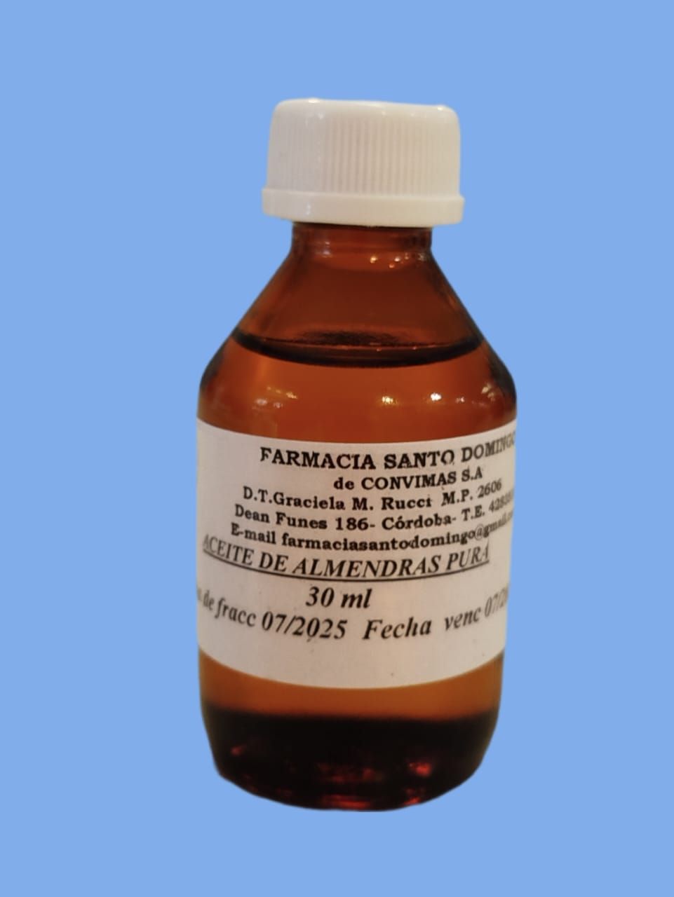 Botella ámbar de aceite de almendras puro con etiqueta, sobre fondo azul.