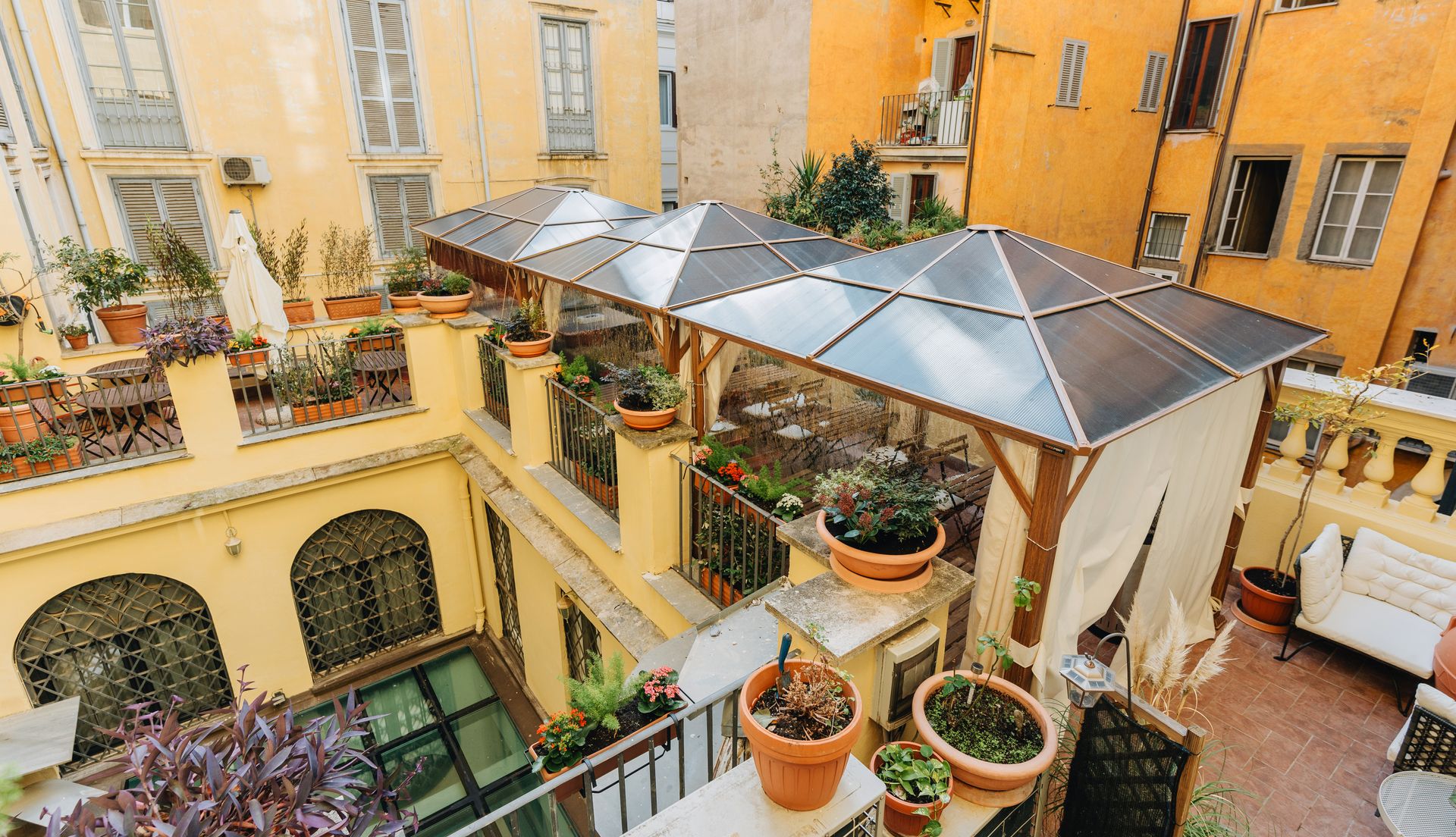 An aerial view of a courtyard filled with potted plants and a gazebo.