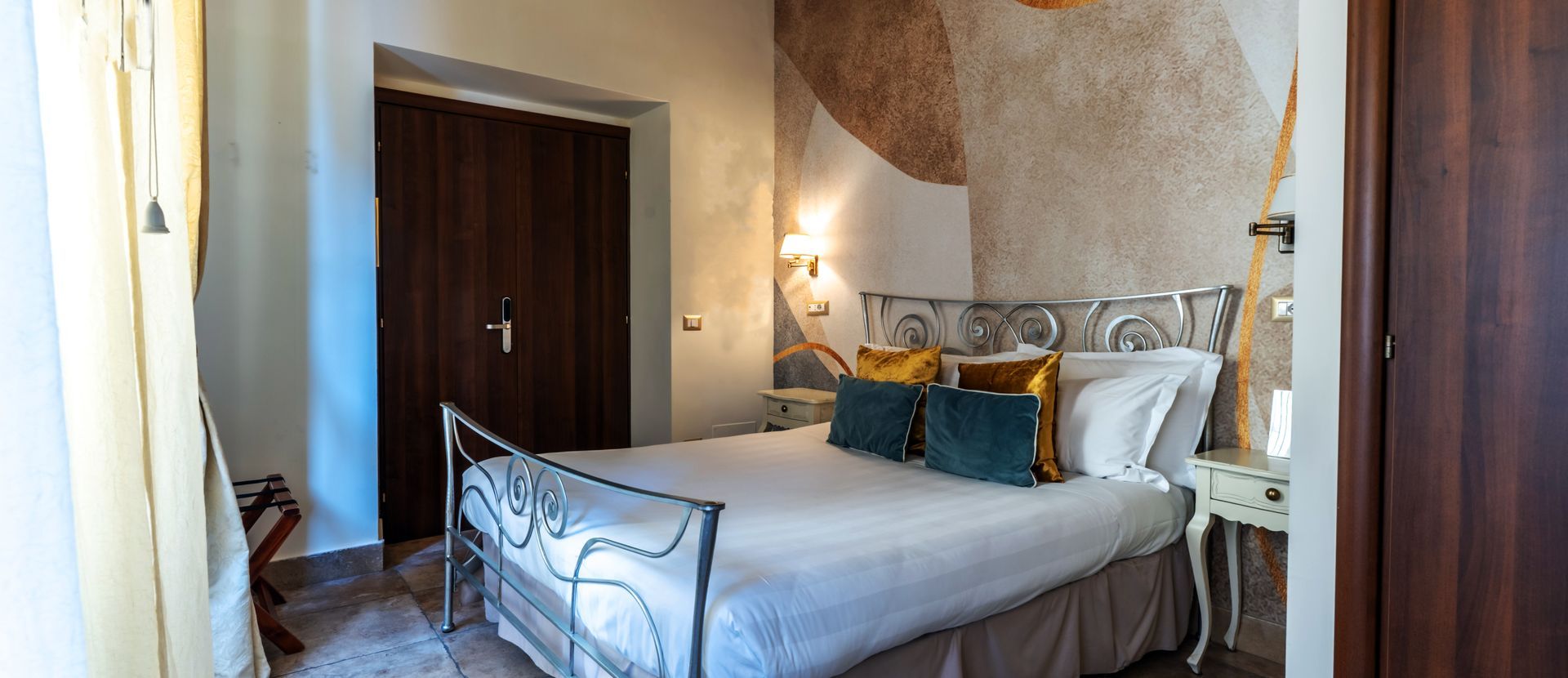 A bedroom with a bed , nightstand , and door.
