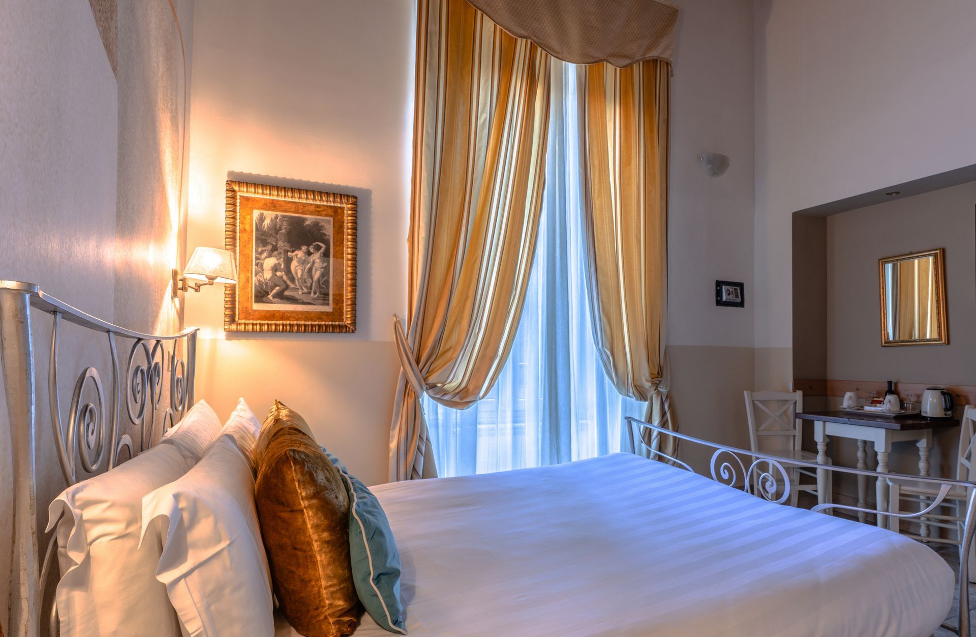 Una stanza d'albergo con un letto grande e un quadro sul muro.