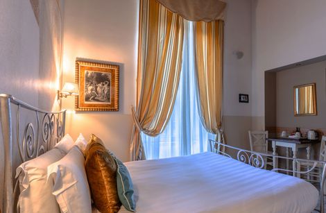 A hotel room with a large bed and a painting on the wall.