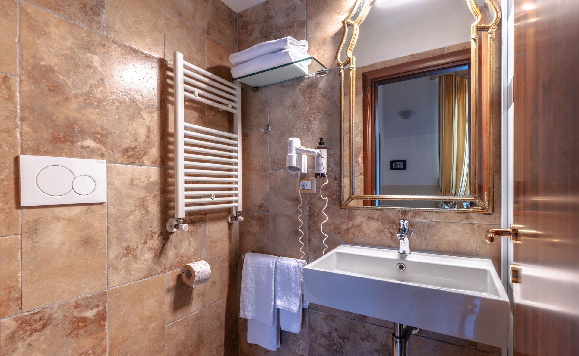 A bathroom with a sink , mirror and towel rack.