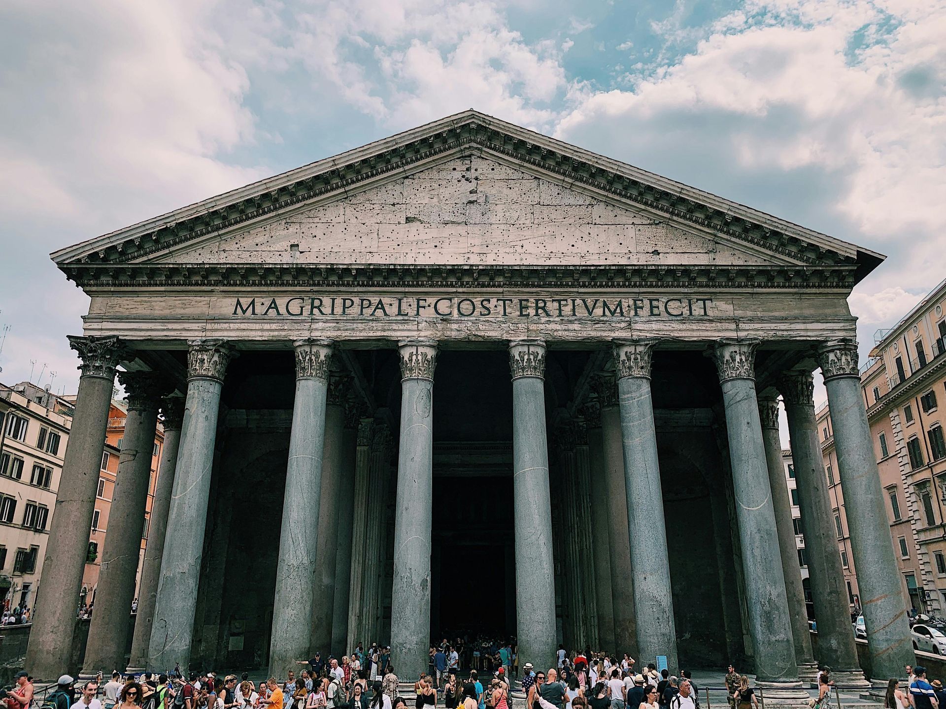 A group of people are standing in front of a large building.