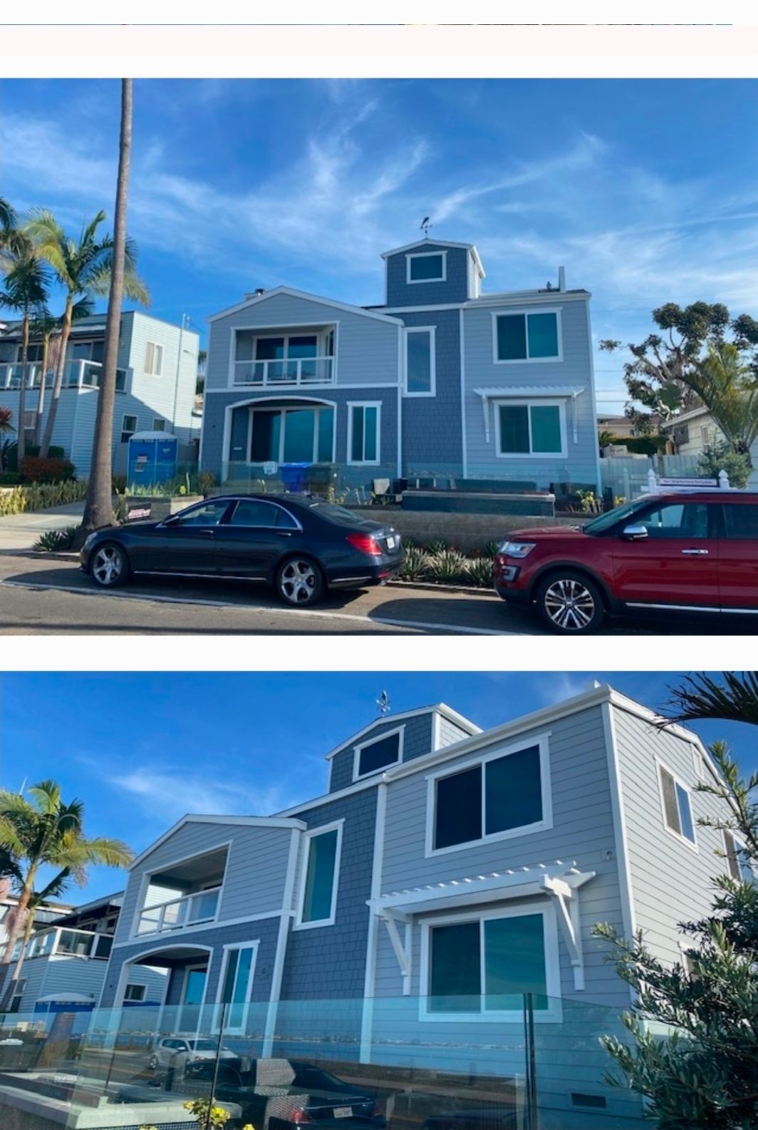 Two-story blue house with white trim, seen from the street with parked cars under a clear sky