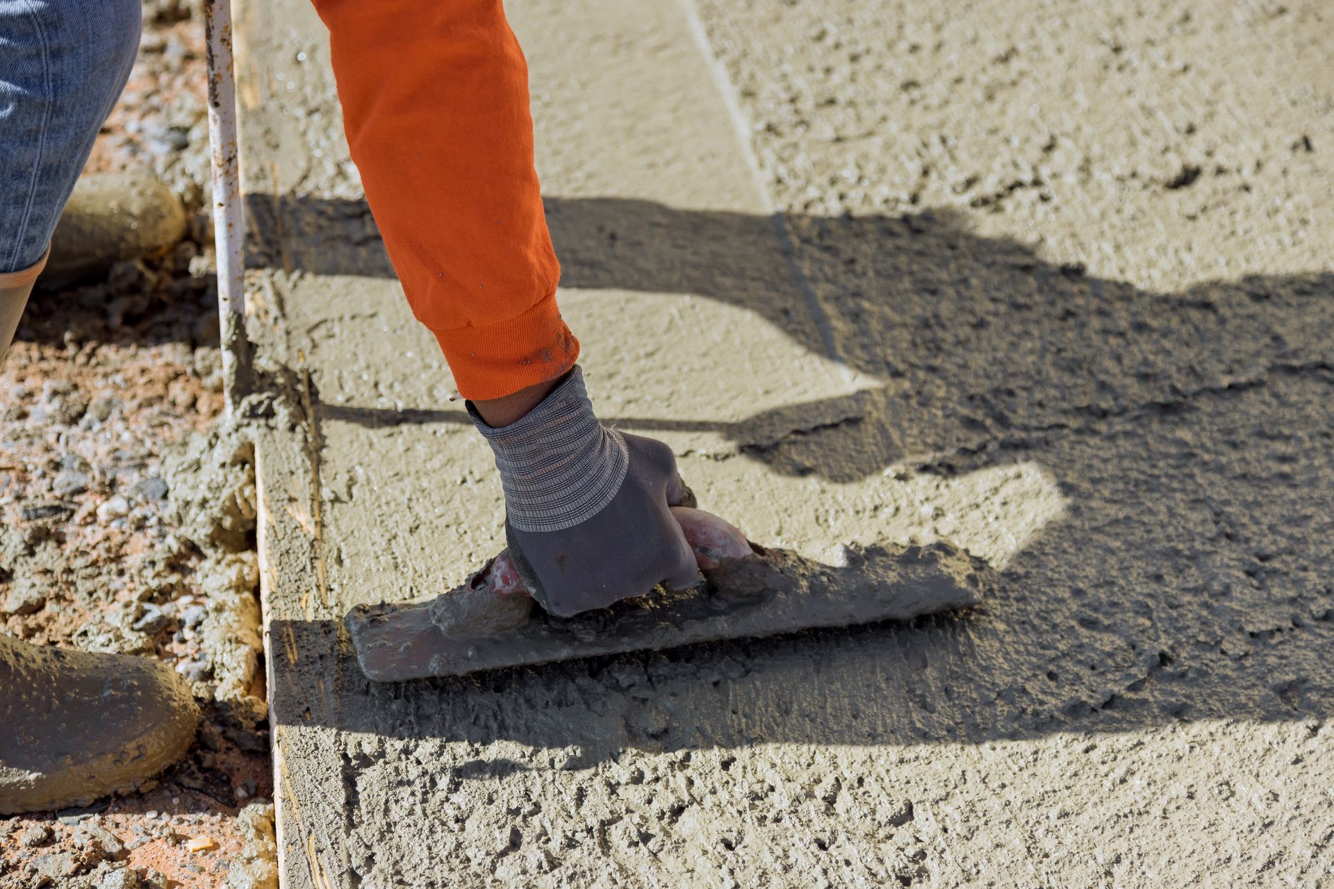 Builder hand leveling concrete with trowel. Builder hand leveling concrete with trowel.