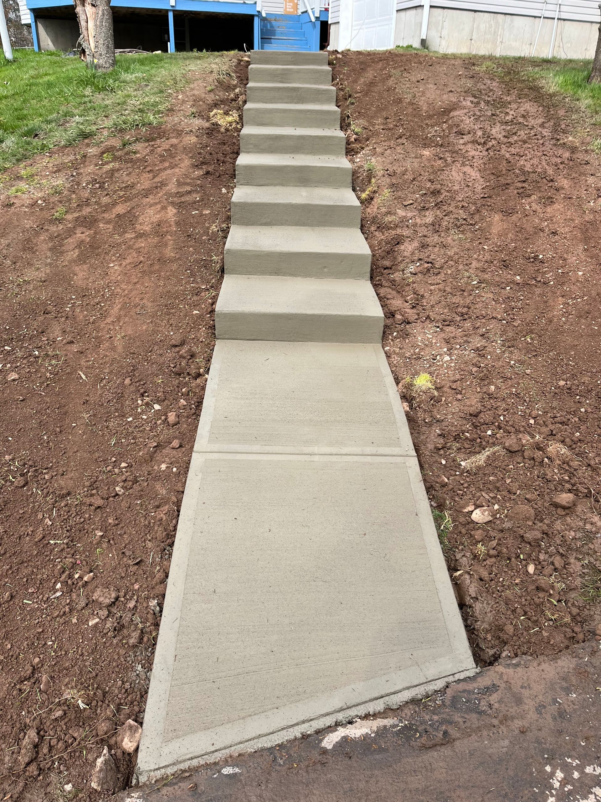 Concrete steps and walkway ascending a hillside.