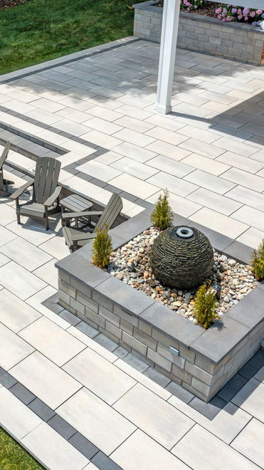 Backyard patio with outdoor seating, hot tub, and covered deck beneath a brick house.
