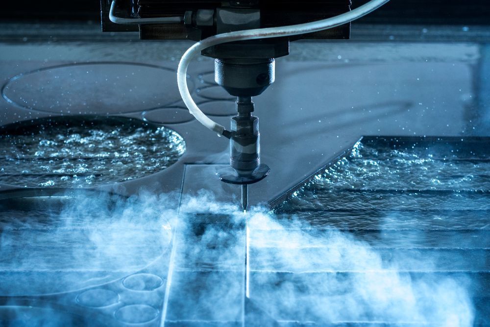 A Machine is Cutting a Piece of Metal With Water and Smoke Coming Out of It — NQBC Pty Ltd in Bowen, QLD