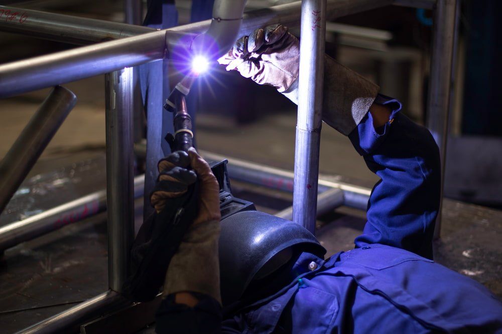 A Man is Welding a Metal Structure in a Factory — NQBC Pty Ltd in Bowen, QLD